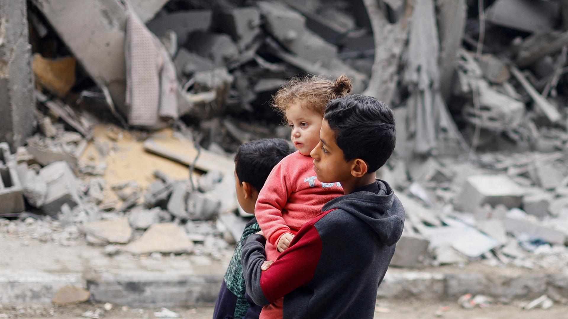 Palästinensische Kinder vor den Trümmern in Rafah