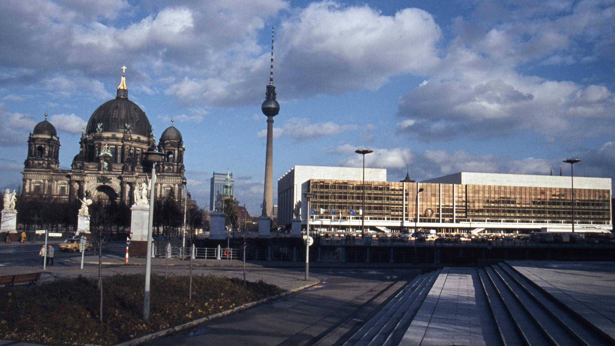 Eine Stadtansicht von Berlin mit dem Berliner Dom links und dem Palast der Republik rechts.