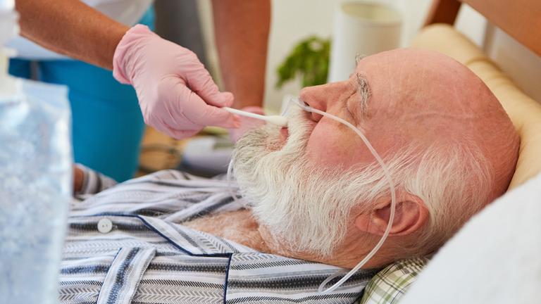 Krankenschwester befeuchtet Lippen von Patient. (Symbolbild)