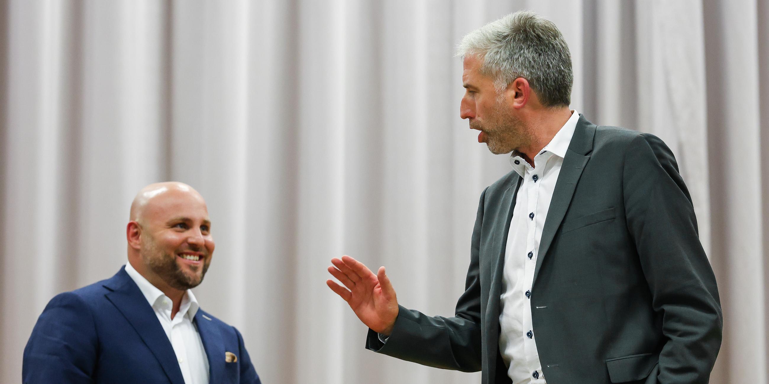 Der AfD-Landesvorsitzende Markus Frohnmaier (l) und Tübingens Oberbürgermeister Boris Palmer (parteilos) während der Diskussionsrunde in der Hermann-Hepper-Halle in Tübingen.