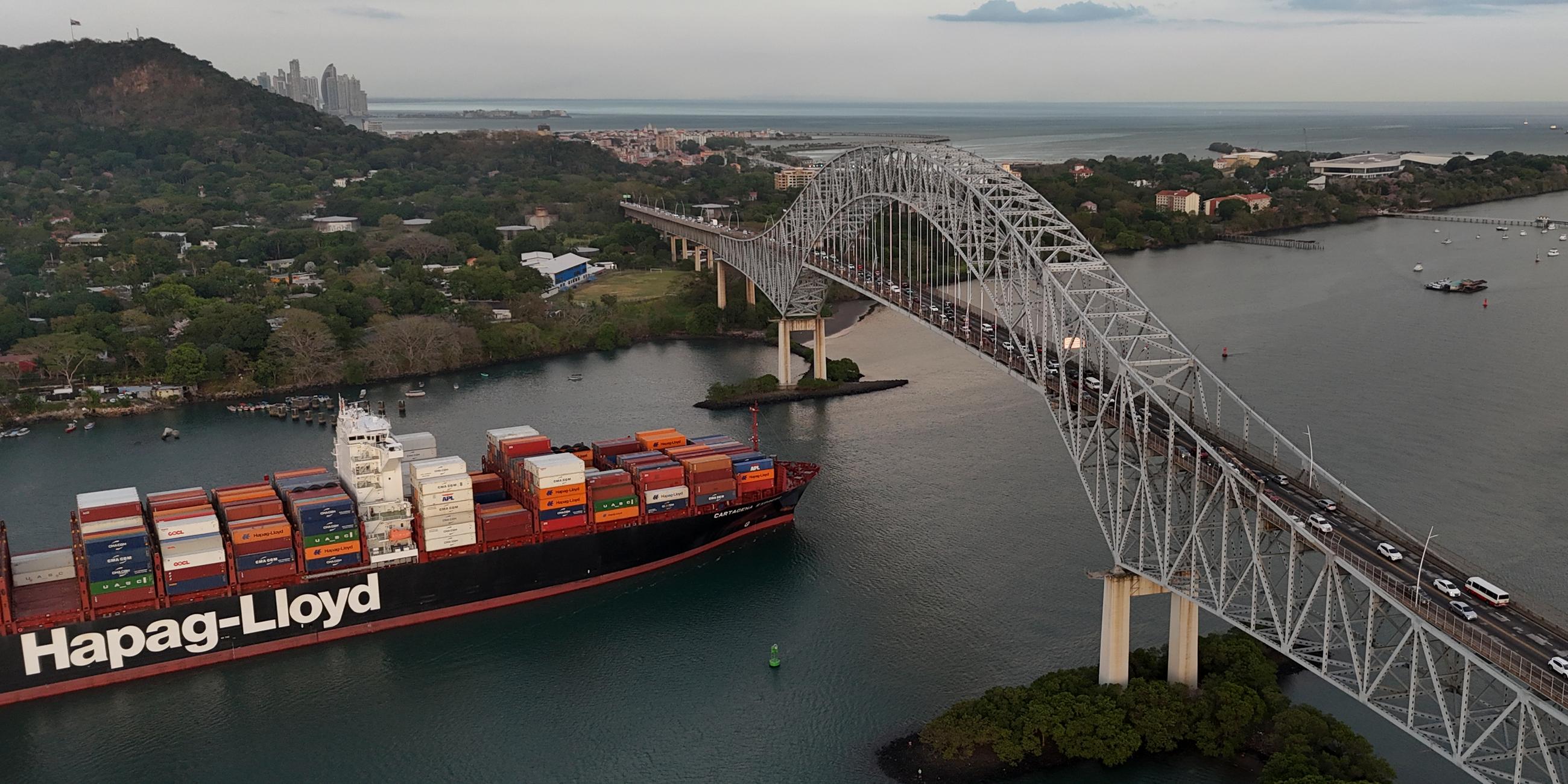 Ein Frachtschiff fährt unter der Las Americas-Brücke durch den Panamakanal. 