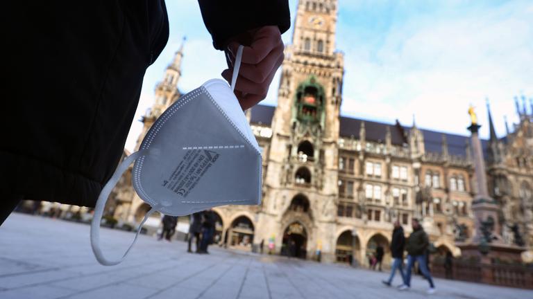 Bayern, München: Eine Frau hält auf dem Marienplatz eine FFP2 Maske. Archivbild