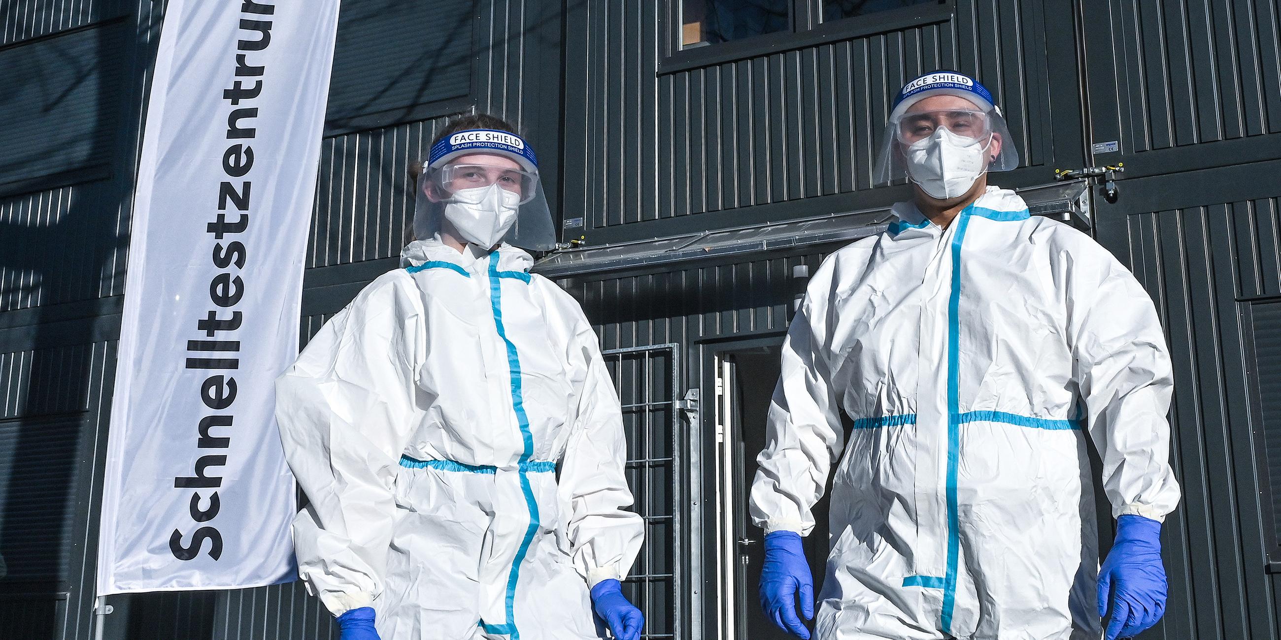 Zwei Helfer vor dem Corona-Schnelltestcenter des BRK Augsburg in der Plärrerwache.