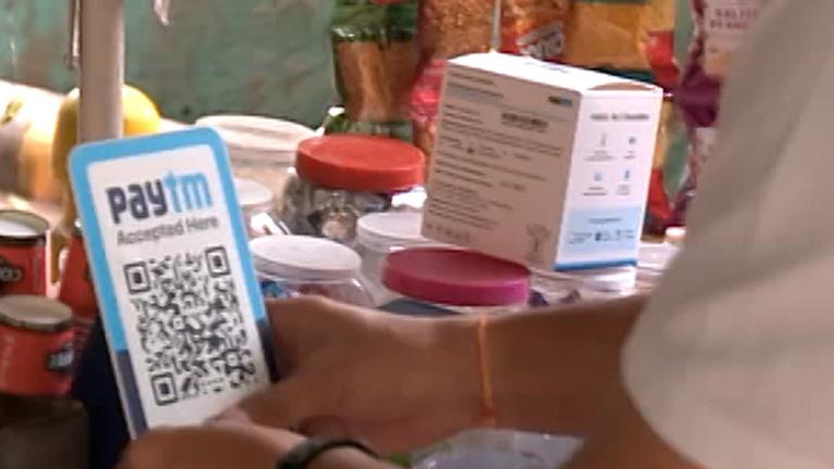 Ein Mann blickt auf einen QR-Code zum digitalen bezahlen.