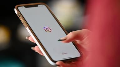 SYMBOLBILD - 03.07.2024, Berlin: Eine Frau öffnet Instagram auf ihrem Smartphone.