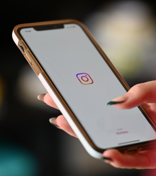 SYMBOLBILD - 03.07.2024, Berlin: Eine Frau öffnet Instagram auf ihrem Smartphone.