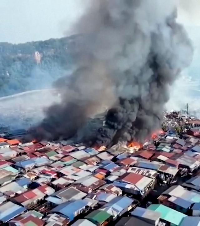 Ein Feuer greift auf Stelzenhäuser in der malaysischen Küstenstadt über
