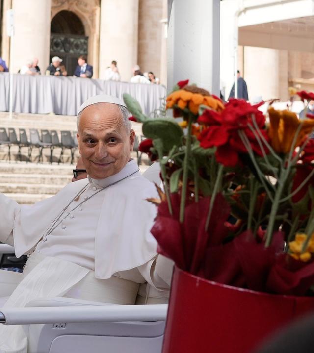 Papst Leo XIV. erhält Blumen, als er am am Ende der Generalaudienz auf dem Petersplatz im Vatikan den Platz verlässt