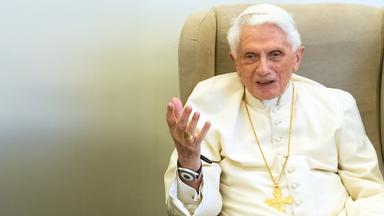 Papst Benedikt sitzt auf einem Sessel und gestikuliert