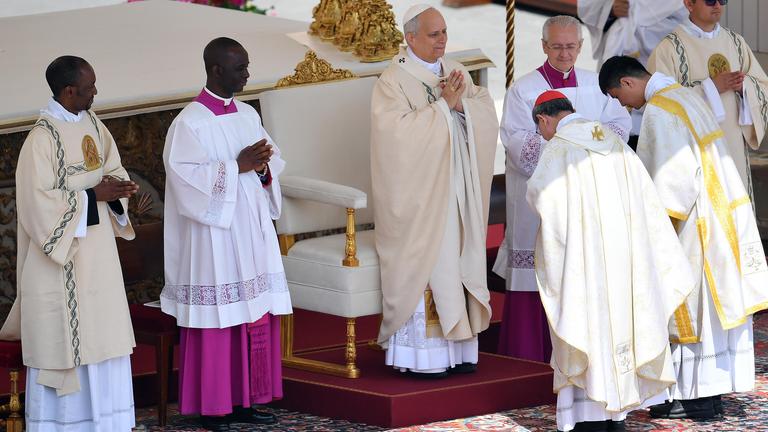 Filipino cardinal Luis Antonio Gokim Tagle puts the Fisherman s Ring on the finger of Pope Leo XIV during a mass for the beginning of his pontificate, in St Peter s square.