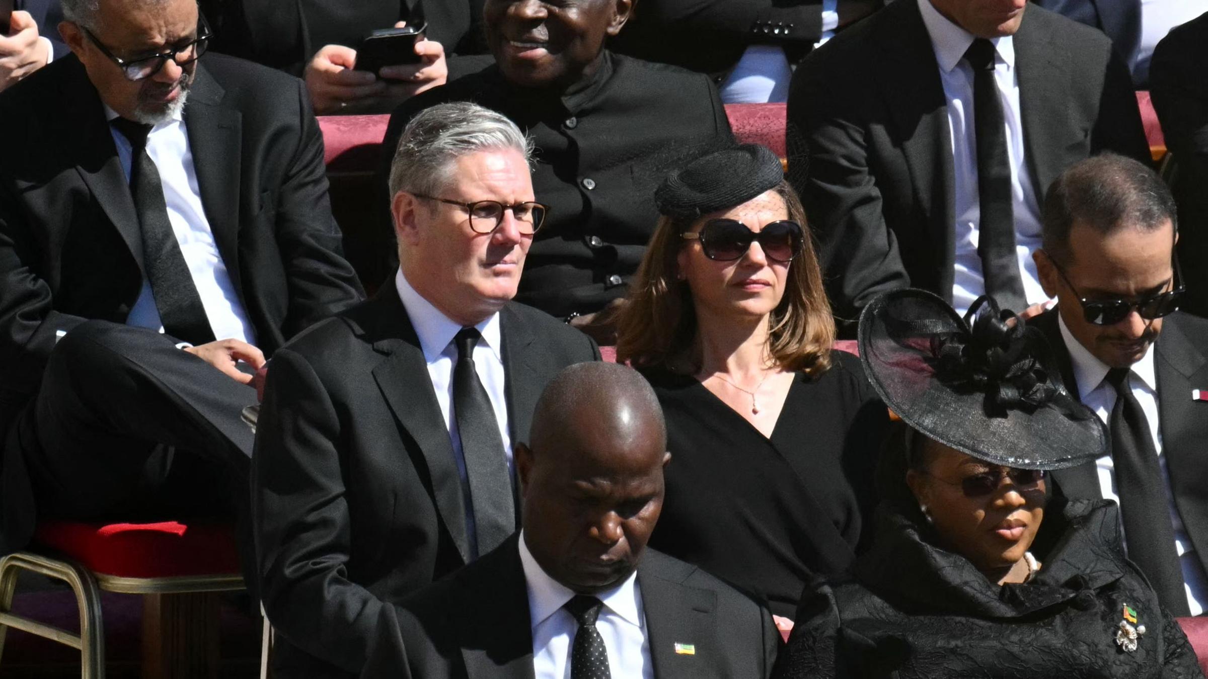 Der britische Premierminister Keir Starmer (Mitte) und seine Frau Victoria Starmer (Mitte/Links) schauen der Trauerfeier für den verstorbenen Papst Franziskus auf dem Petersplatz im Vatikan zu.