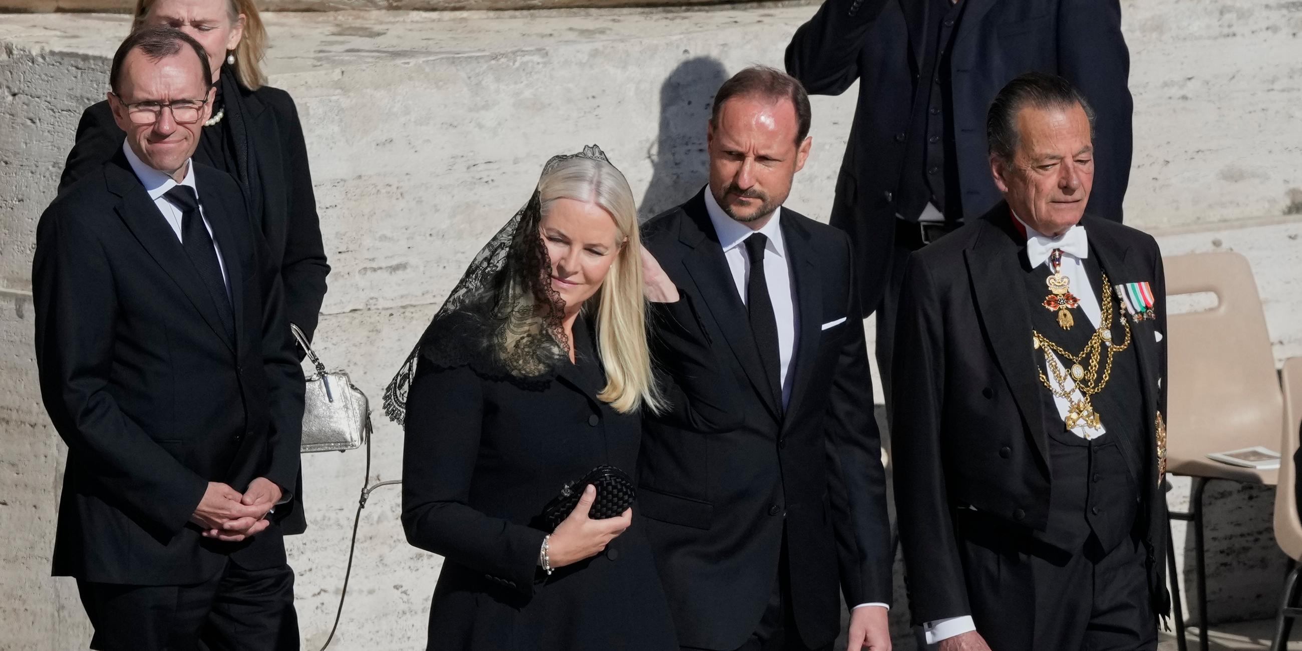 Vatikan, Vatikanstadt: Kronprinz Haakon von Norwegen (M,r) und Mette-Marit, Kronprinzessin von Norwegen, kommen zur Trauermesse für den verstorbenen Papst Franziskus auf dem Petersplatz.