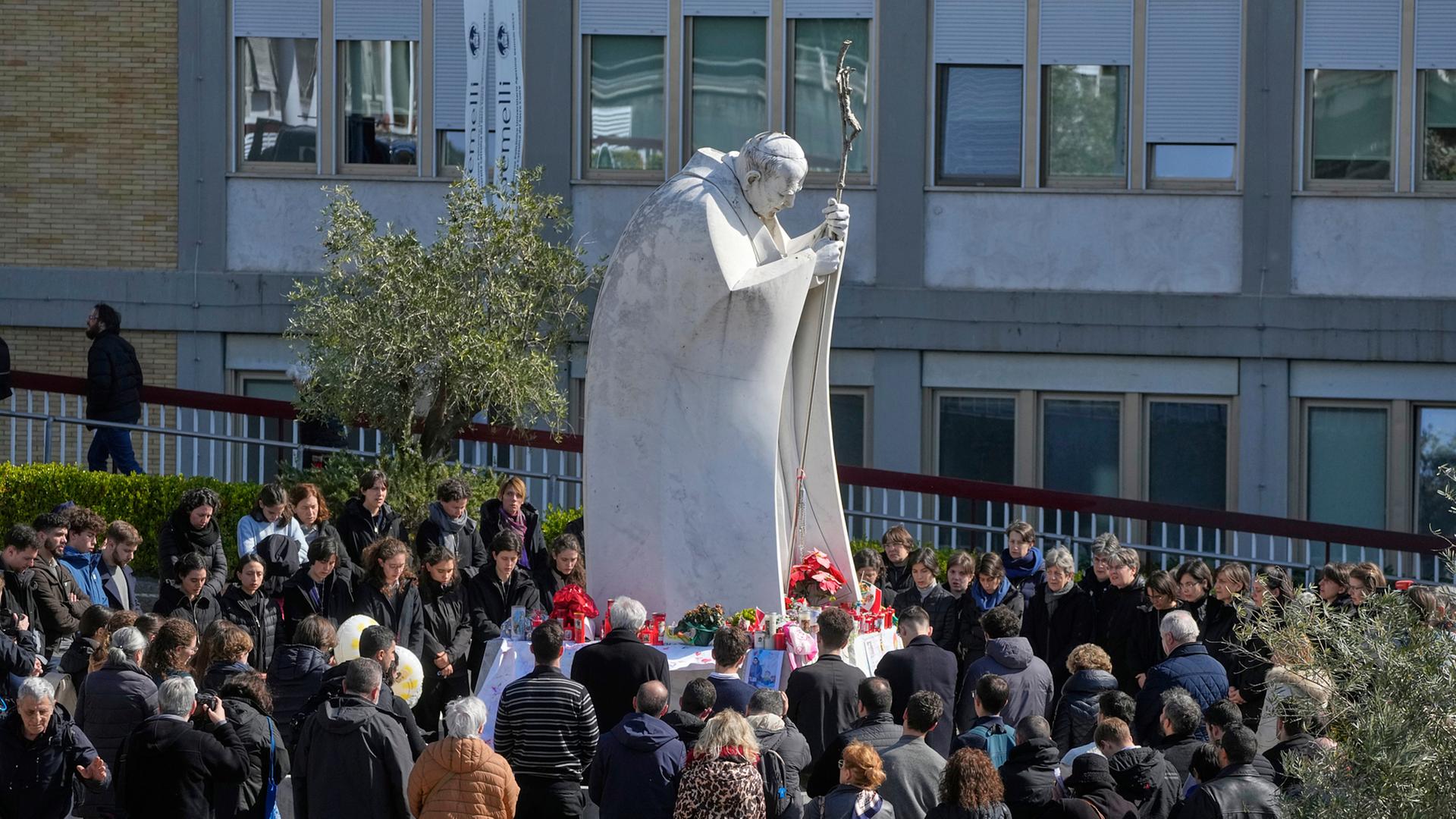 Italien, Rom: Gläubige versammeln sich zum Gebet um die Statue von Johannes Paul II. vor der Poliklinik Agostino Gemelli, wo Papst Franziskus im Krankenhaus liegt.