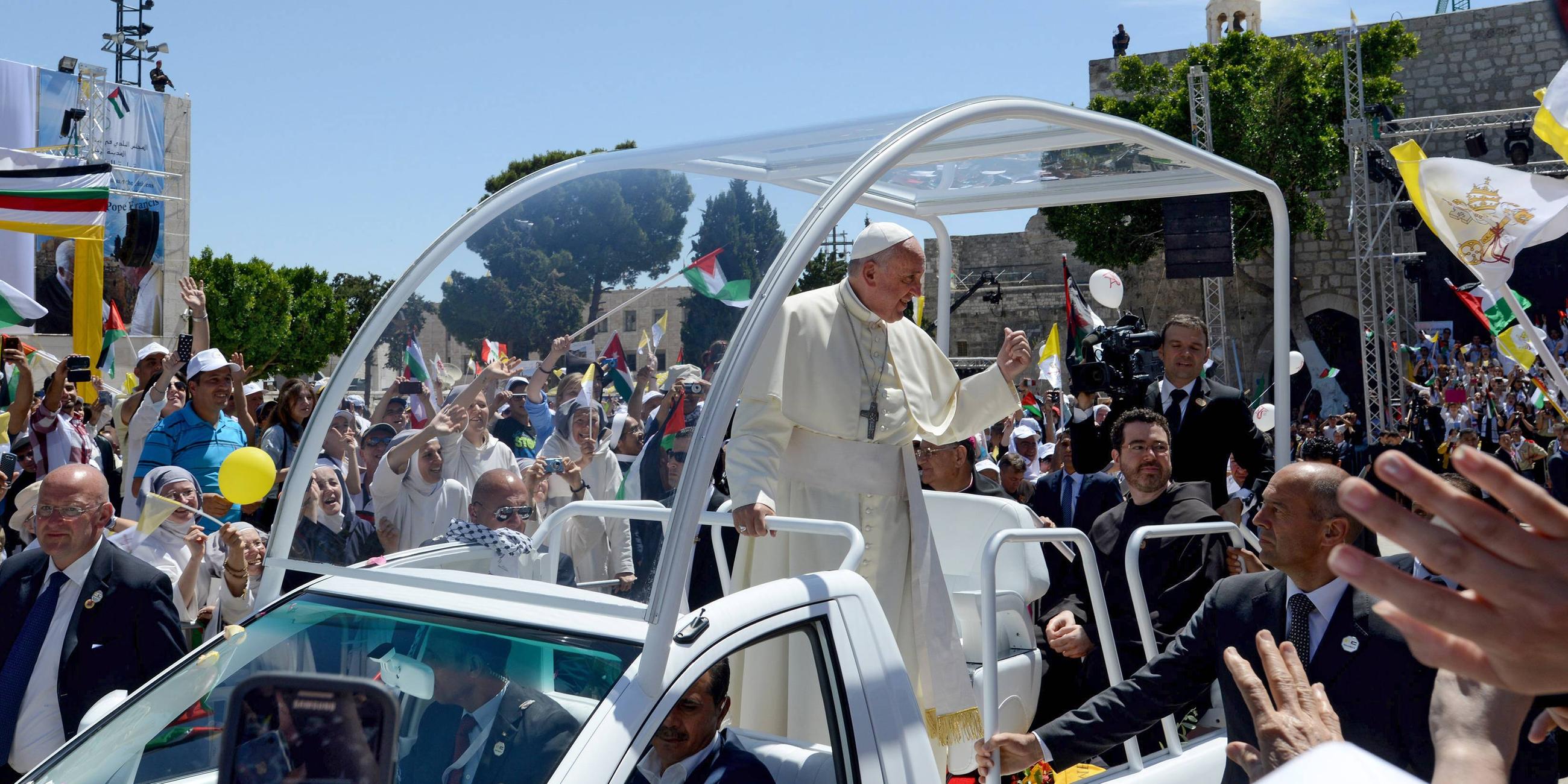 Papst Franziskus trifft am Sonntag (25.05.14) in seinem Papamobil auf dem Krippenplatz vor der Geburtskirche in Bethlehem (Palästinensisches Autonomiegebiet) zu eine Messe unter freiem Himmel ein und begruesst die Teilnehmer.