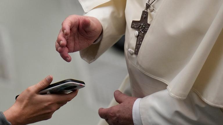 Papst Franziskus segnet ein Foto auf einem Smartphone