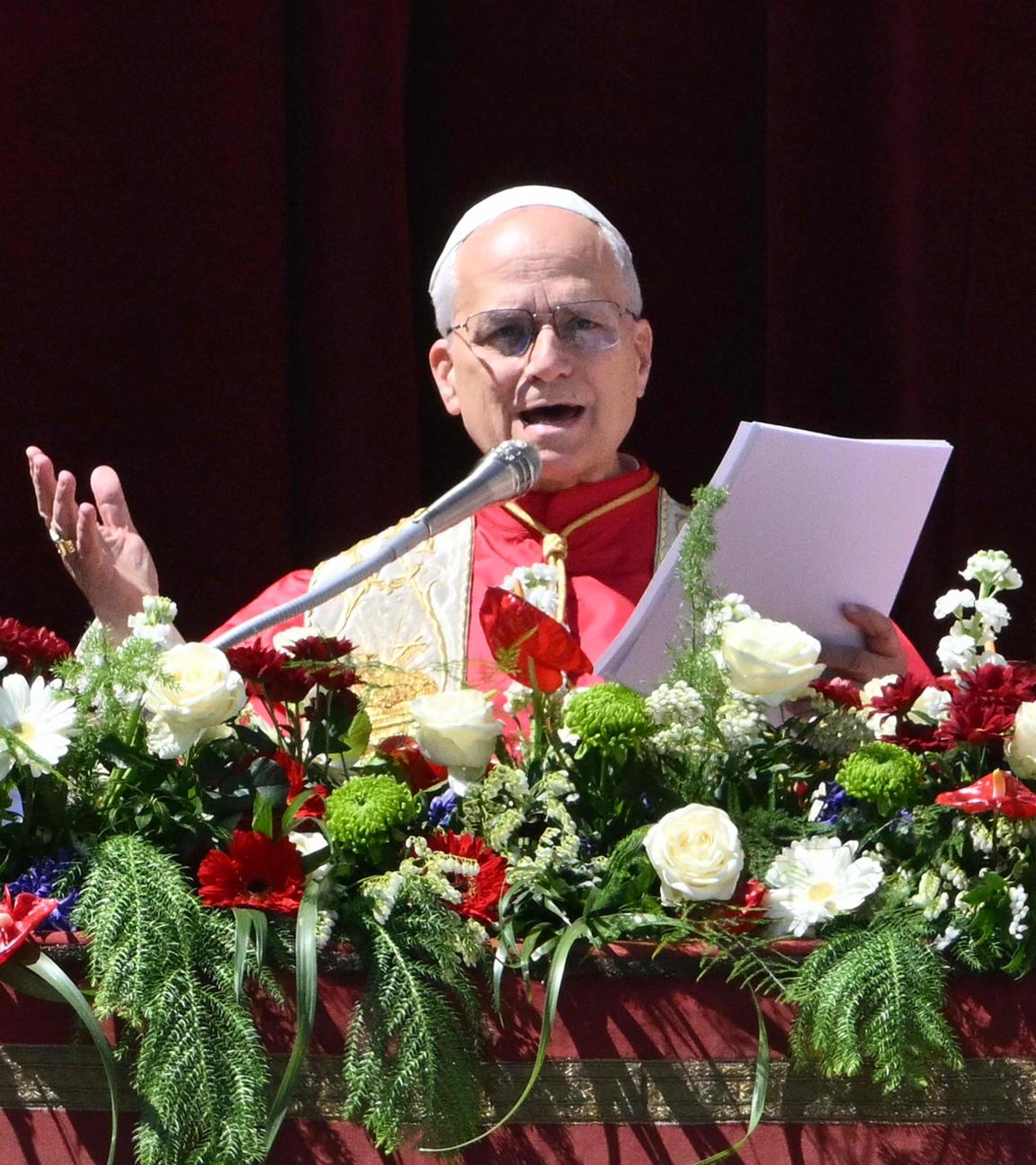 Papst Leo XIV. steht auf dem Hauptbalkon des Petersdoms, vor ihm sind Blumen am Geländer angebracht.