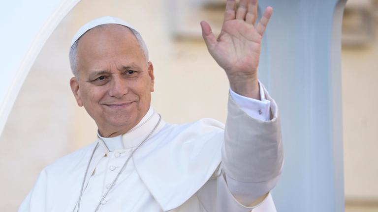 Papst Leo XIV. winkt ganz in weiß gekleidet aus dem Papamobil.