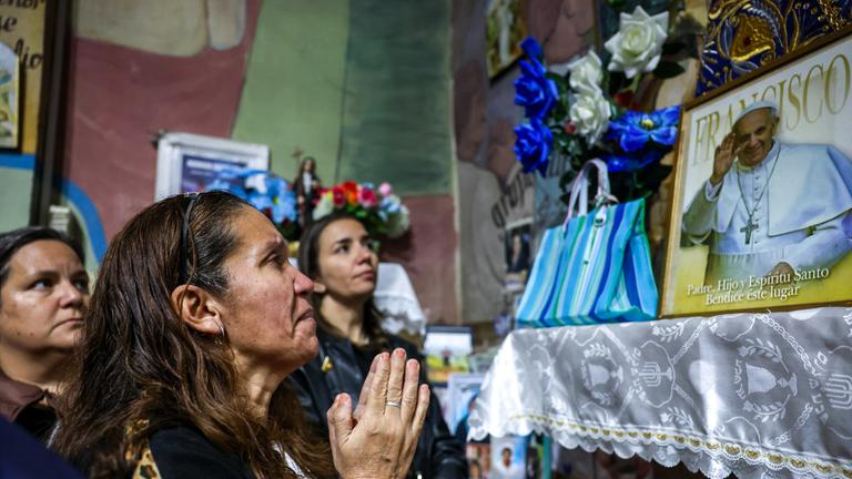 21.04.2025, Argentinien, Buenos Aires: Gläubige beten in der Pfarrei Unsere Liebe Frau der Wunder von Caacupe, um nach der Bekanntgabe des Todes von Papst Franziskus eine Messe zu feiern in Buenos Aires, Argentinien.