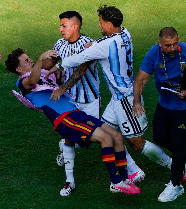 Spaniens Gavi stürzt bei einer Raneglei mit Leandro Paredes (Nummer 5) und Thiago Almada zu Boden