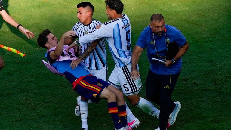 Spaniens Gavi stürzt bei einer Raneglei mit Leandro Paredes (Nummer 5) und Thiago Almada zu Boden
