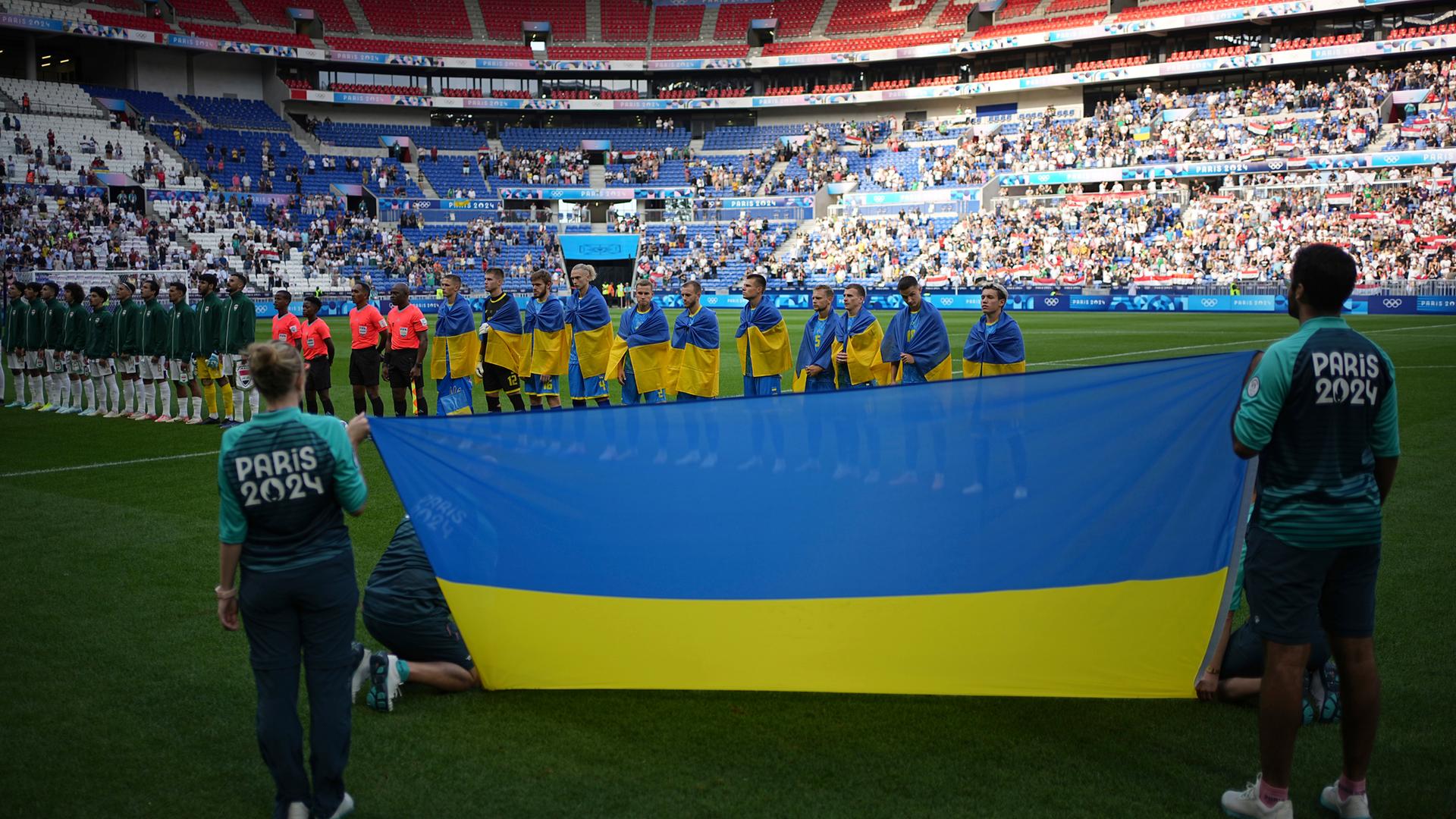 Olympia, Olympische Sommerspiele, Paris 2024, Fußball, Irak - Ukraine, Vorrunde, Gruppe B, 1. Spieltag, die ukrainischen Spieler hören sich vor dem Spiel die Nationalhymne an. 
