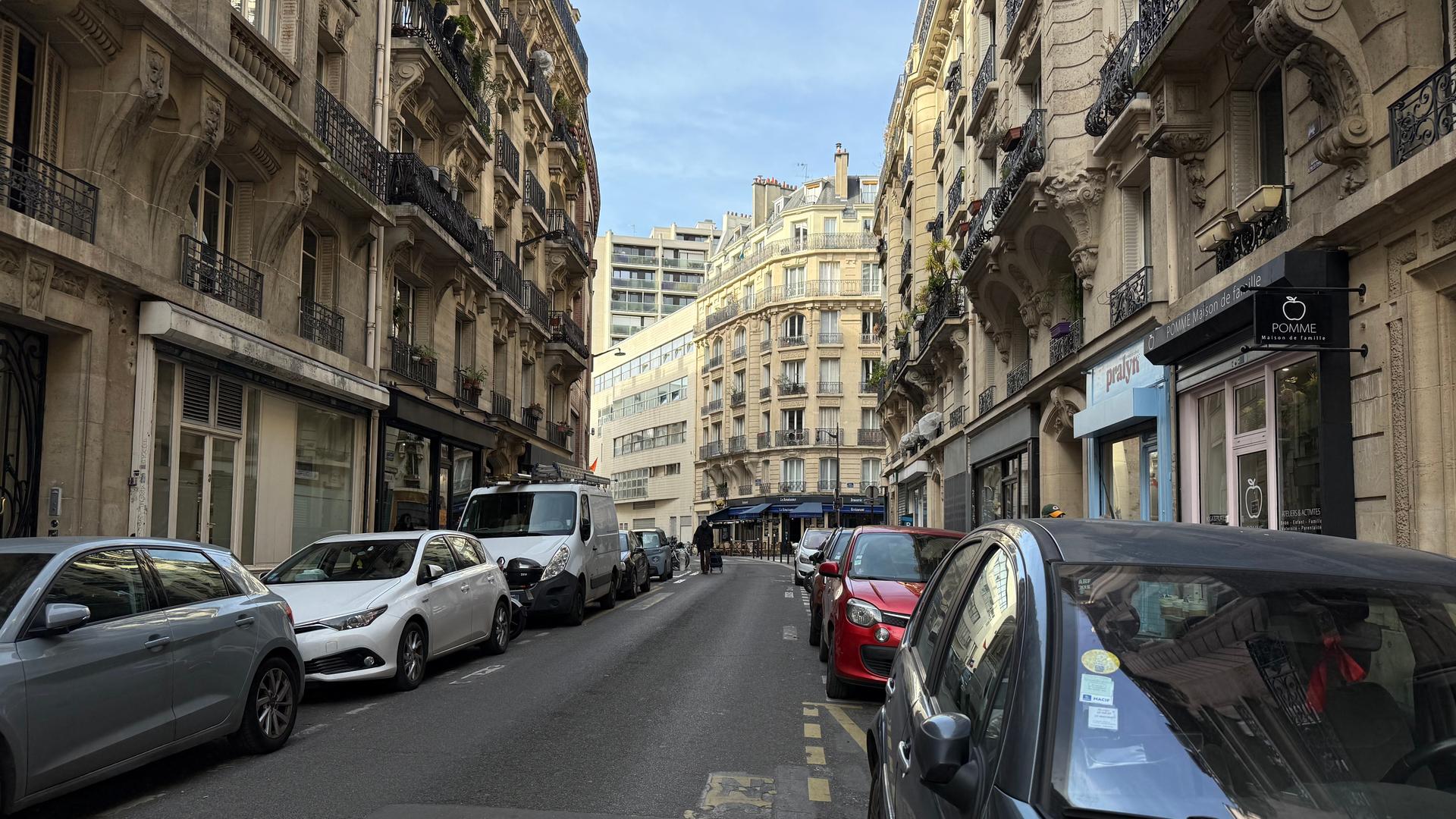 Viele Straßen in Paris sind eng, an ihren Rändern drängen sich parkende Autos.