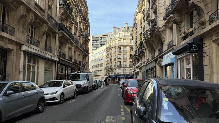 Viele Straßen in Paris sind eng, an ihren Rändern drängen sich parkende Autos.