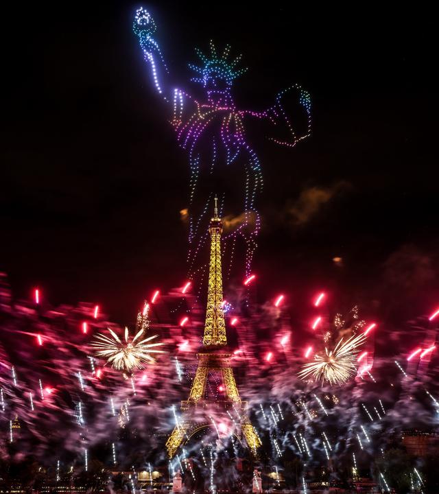 Feuerwerk und Drohnen über dem Eiffelturm in Paris am Vorabend des französischen Nationalfeiertags.