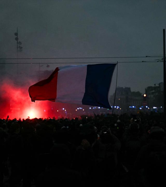 Ein Demonstrant schwenkt in der Nähe der Porte de Vincennes in Paris eine französische Flagge. Die Kundgebung am 24. Oktober 2026 fand im Rahmen eines landesweiten Mobilisierungsaufrufs statt, der ehemalige Mitglieder der „Gelbwesten“-Bewegung, Gewerkschaften sowie Schüler und Studierende zusammenbrachte; gefordert wurden unter anderem eine Stärkung der Kaufkraft, der Schutz öffentlicher Dienste sowie Steuer- und Sozialgerechtigkeit.