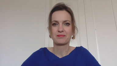 Ungarn-Expertin Barlai per Video zugeschaltet. Ihr Hintergrund eine weiße Wand und eine weiße Tür