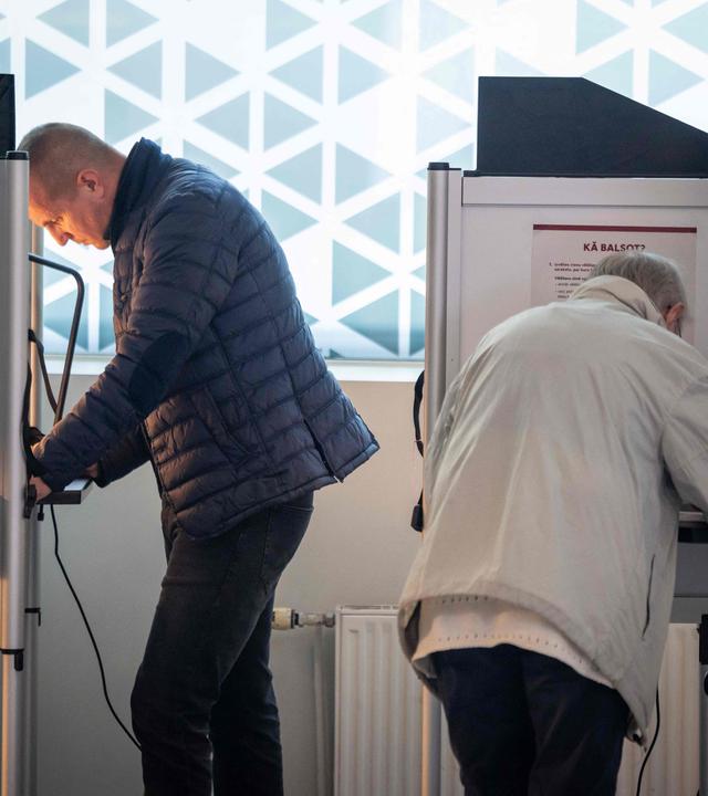 Menschen bei der Wahl in einem Wahllokal in Riga.