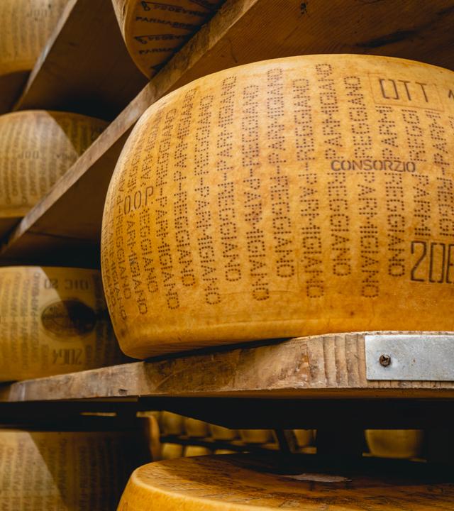 Ein zertifizierter Parmigiano-Reggiano-Käselaib, der im Lager eines Käsereibetriebs reift.
