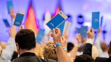  30.05.2026, Brandenburg, Brandenburg an der Havel: Parteimitglieder halten beim Parteitag der AfD Berlin im Stahlpalast in Brandenburg an der Havel Stimmkarten in die Höhe. Auf der Tagesordnung steht unter anderem der Beschluss des Wahlprogramms zur Wahl des Berliner Abgeordnetenhauses am 20. September 2026.