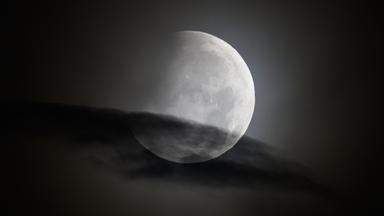 Der Mond geht am Morgen während einer partiellen Mondfinsternis unter. 