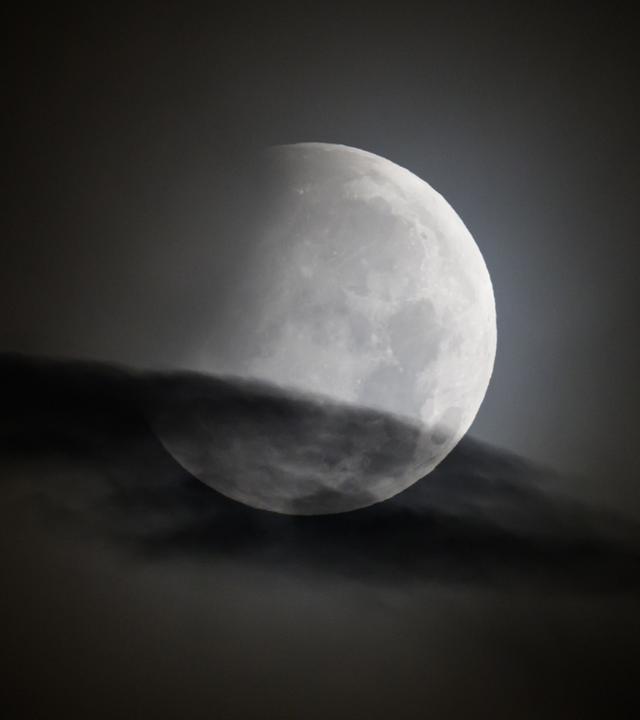 Der Mond geht am Morgen während einer partiellen Mondfinsternis unter. 