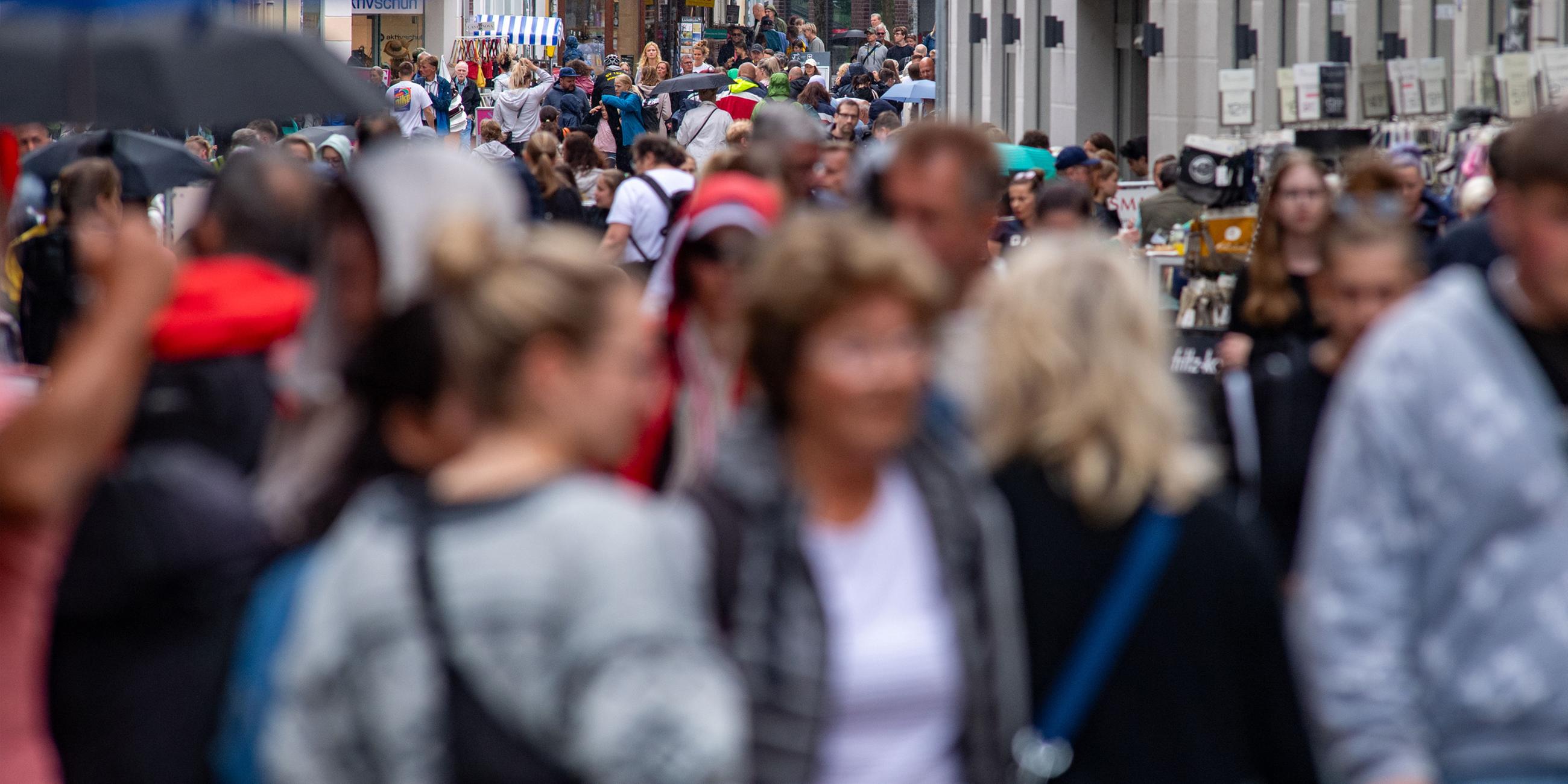 Passanten gehen durch die Einkaufstraße Ossenreyerstraße in Stralsund