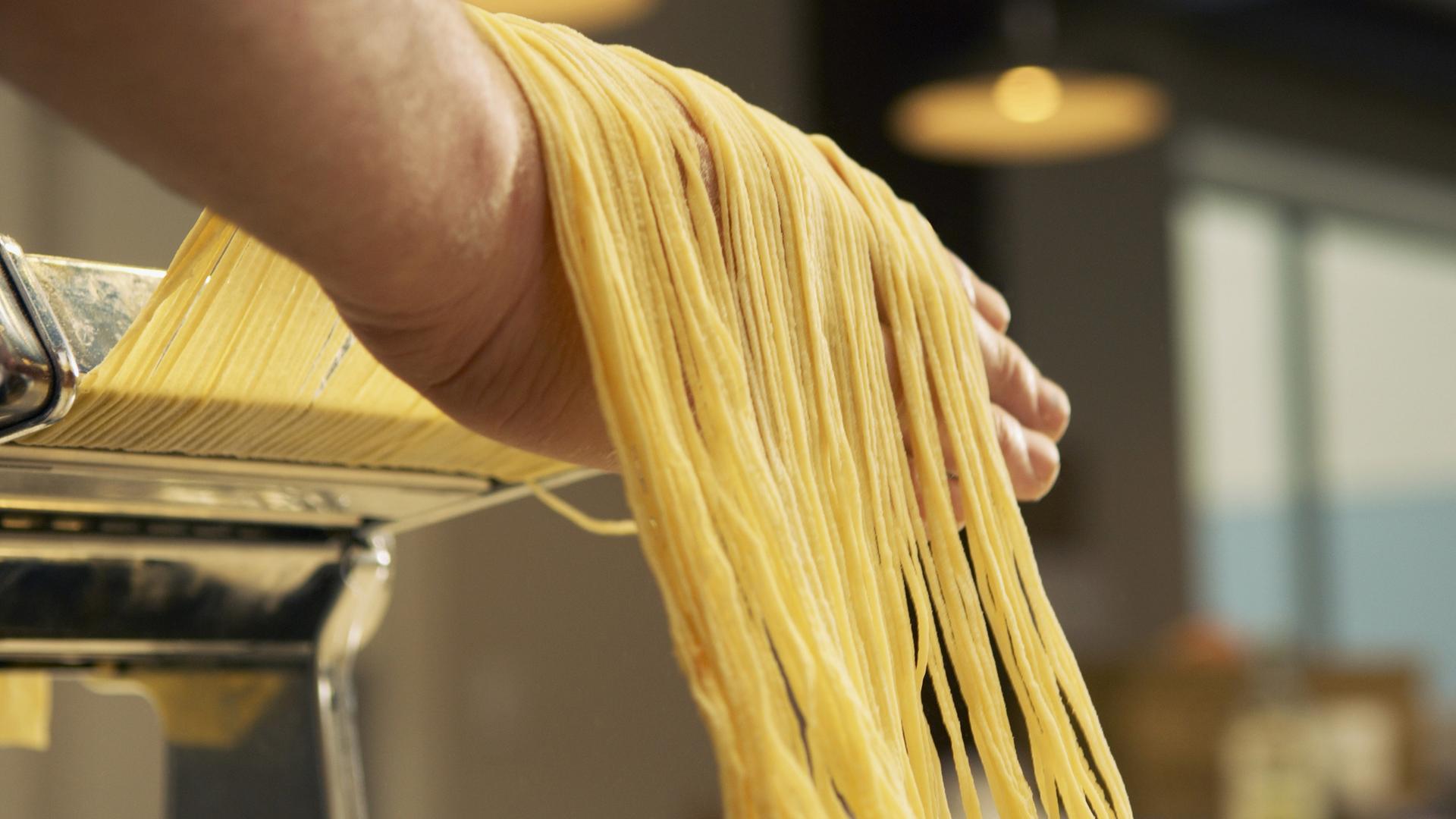 Spaghetti werden mit einer Nudelmaschine hergestellt.
