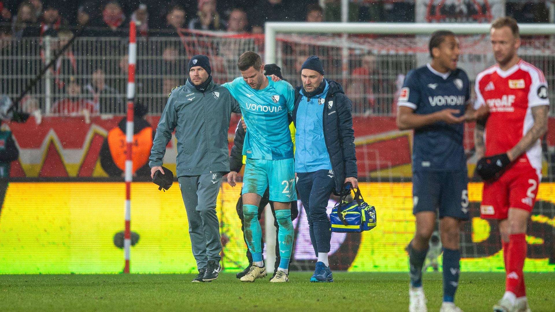 Bochums Torwart Patrick Drewes wird nach dem Feuerzeugwurf im Spiel bei Union Berlin vom Platz geführt.