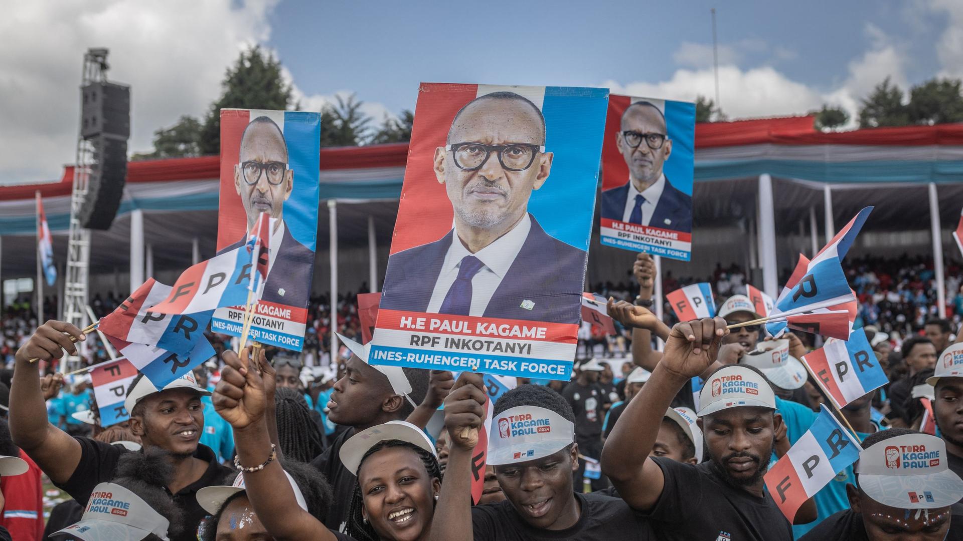 Unterstützer der Ruandischen Patriotischen Front (RPF) halten Fahnen in den Parteifarben und Poster mit dem Präsidenten Paul Kagame in die Höhe.