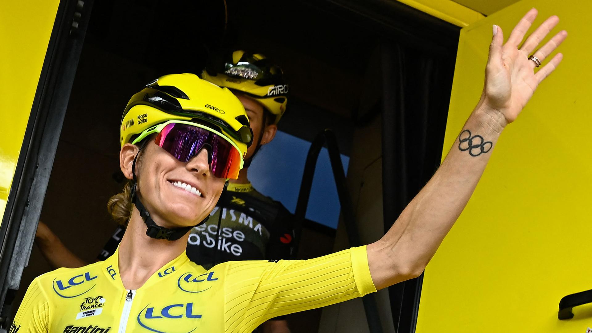 Die Gesamtführende im Gelben Trikot, Pauline Ferrand-Prevot, französische Fahrerin des Teams Visma | Lease a Bike, winkt den Fans zu.