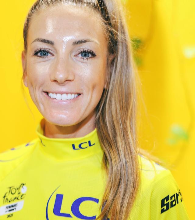 Pauline Ferrand-Prevot, Gesamtsiegerin der Tour de France Femmes 2025, lächelt bei einer Pressekonfenz in die Kamera.