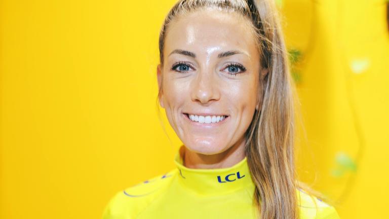 Pauline Ferrand-Prevot, Gesamtsiegerin der Tour de France Femmes 2025, lächelt bei einer Pressekonfenz in die Kamera.