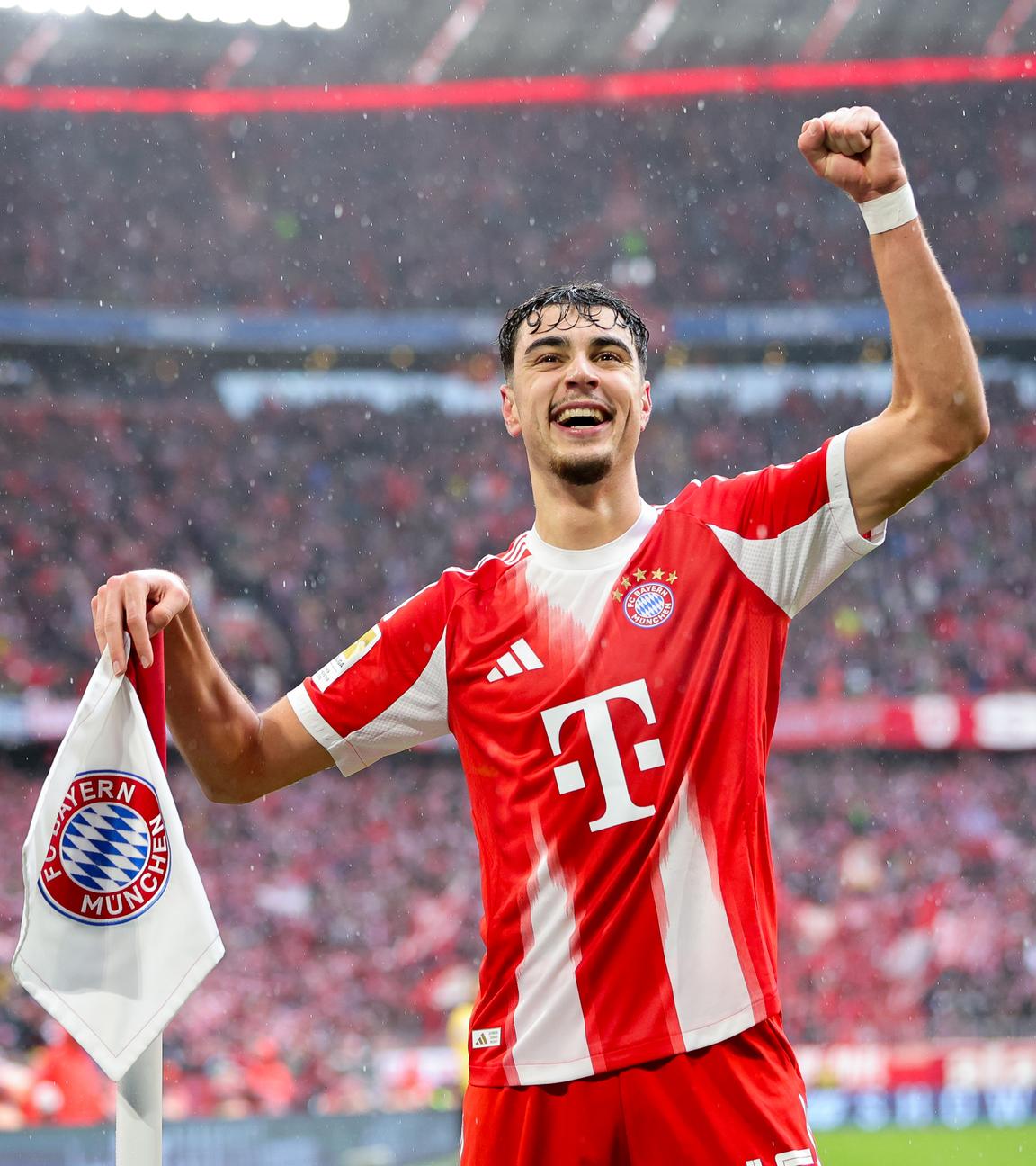 Aleksandar Pavlovic hebt den linken Arm und jubelt an der Eckfahne stehend.