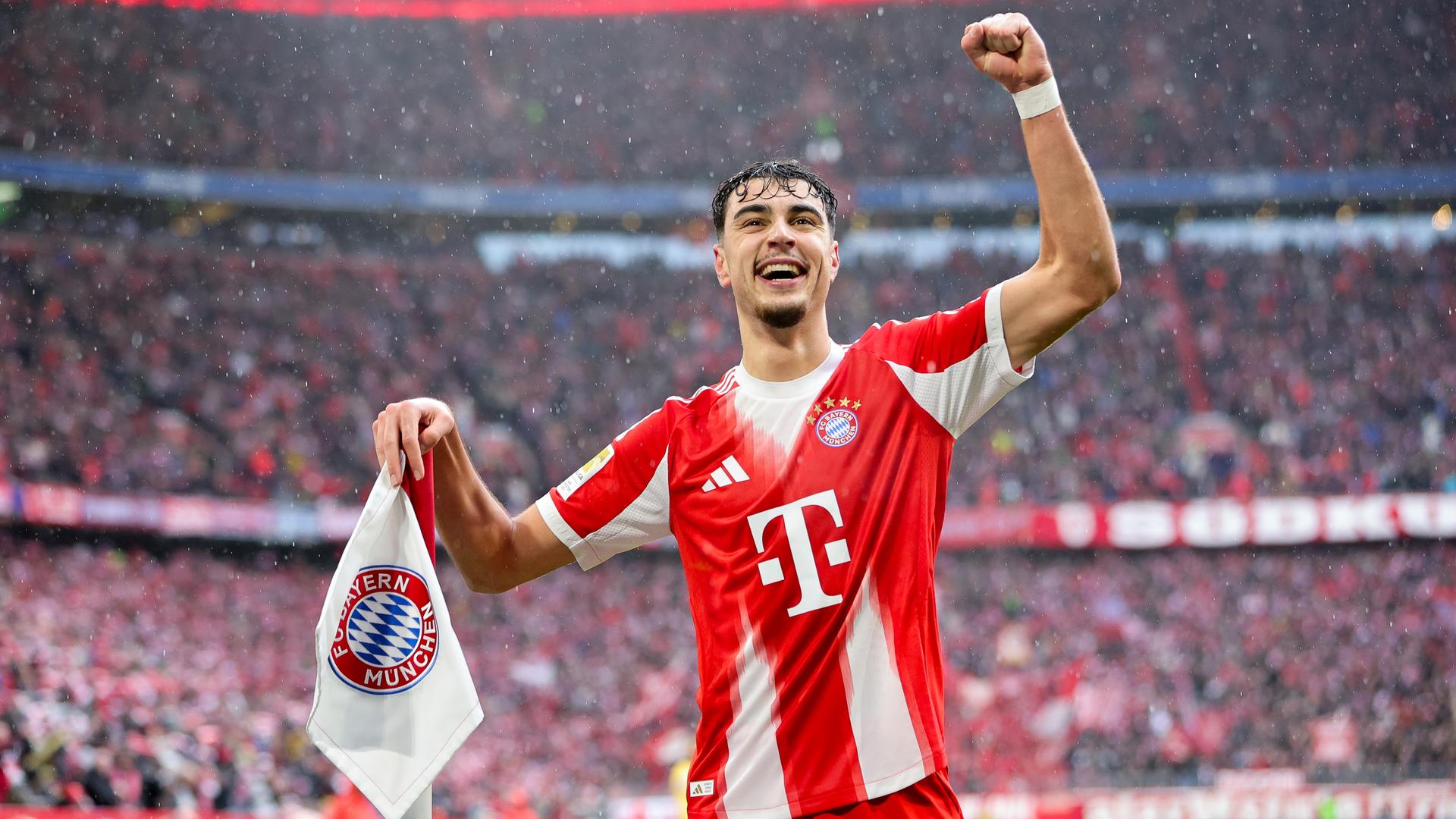 Aleksandar Pavlovic hebt den linken Arm und jubelt an der Eckfahne stehend.