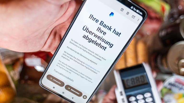 Ein Smartphone zeigt eine Paypal-Mitteilung über eine abgelehnte Überweisung per E-Mail. 