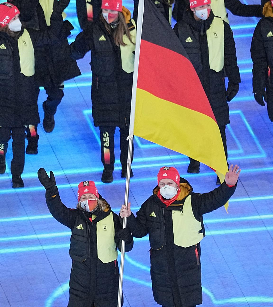 Die deutschen Fahnenträger Francesco Friedrich und Claudia Pechstein laufen mit den deutschen Teilnehmern ein am 04.02.2022 in Beijing.