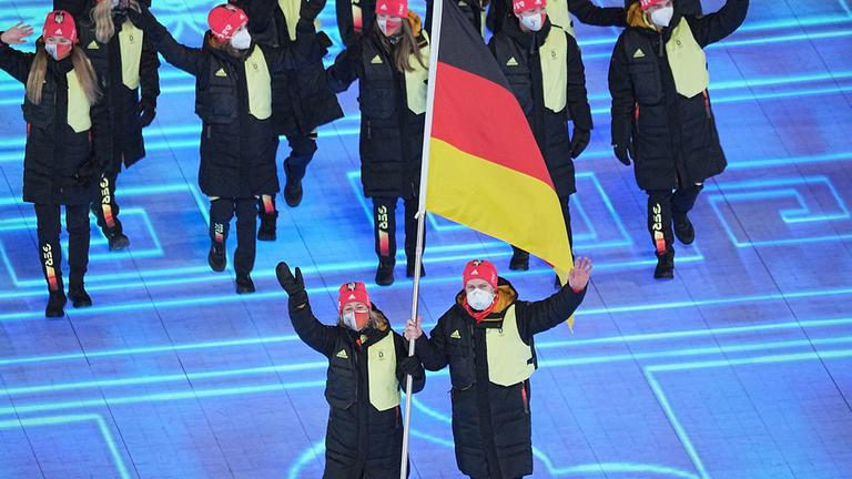 Die deutschen Fahnenträger Francesco Friedrich und Claudia Pechstein laufen mit den deutschen Teilnehmern ein am 04.02.2022 in Beijing.