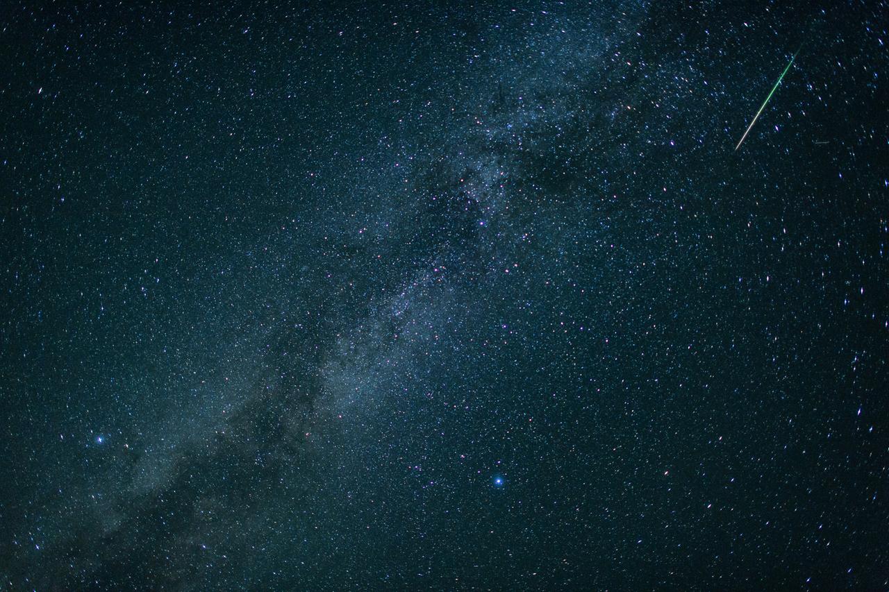 Bayern, Einsiedl: Eine Sternschnuppe leuchtet neben der Milchstraße am Himmel über dem Walchensee.