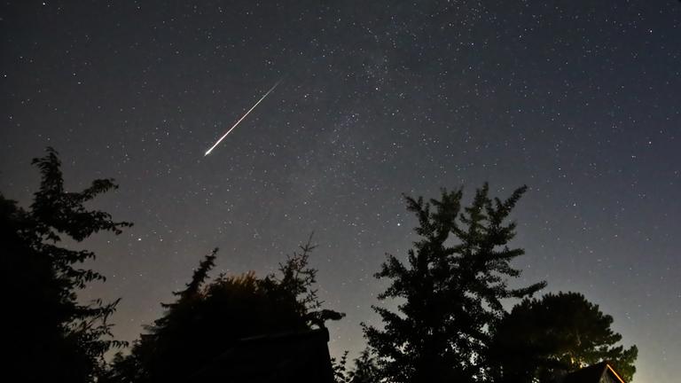 ARCHIV - 13.08.2023, Schleswig-Holstein, Neumünster: Ein Perseidenmeteor zieht über den Himmel.