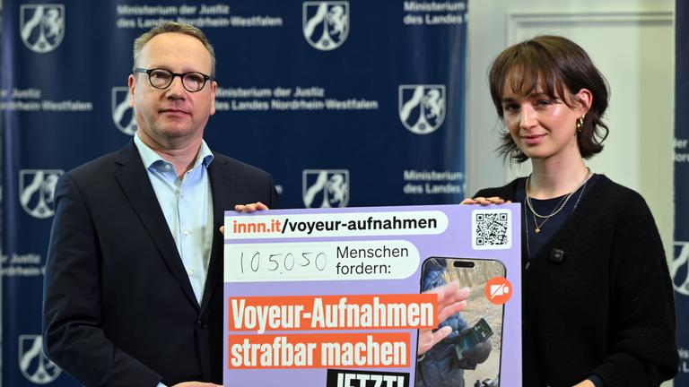 NRW-Justizminister Benjamin Limbach (Grüne, l) nimmt von Yanni Gentsch eine Petition entgegen.